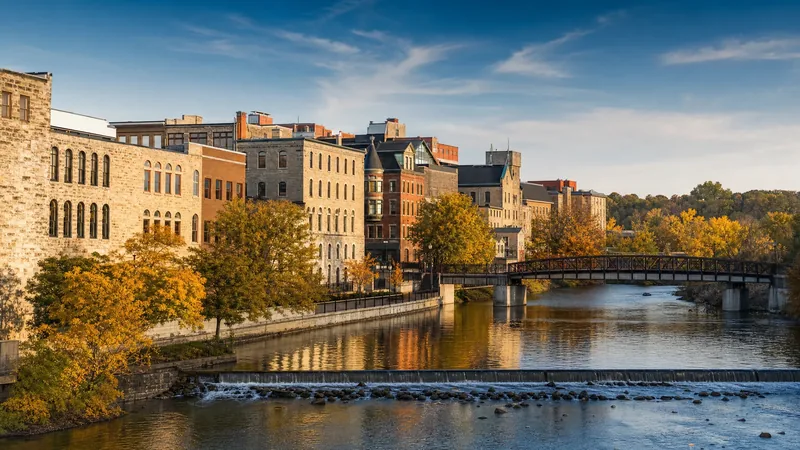 Riverfront downtown with limestone and brick buildings beside a river, Kane County Business License